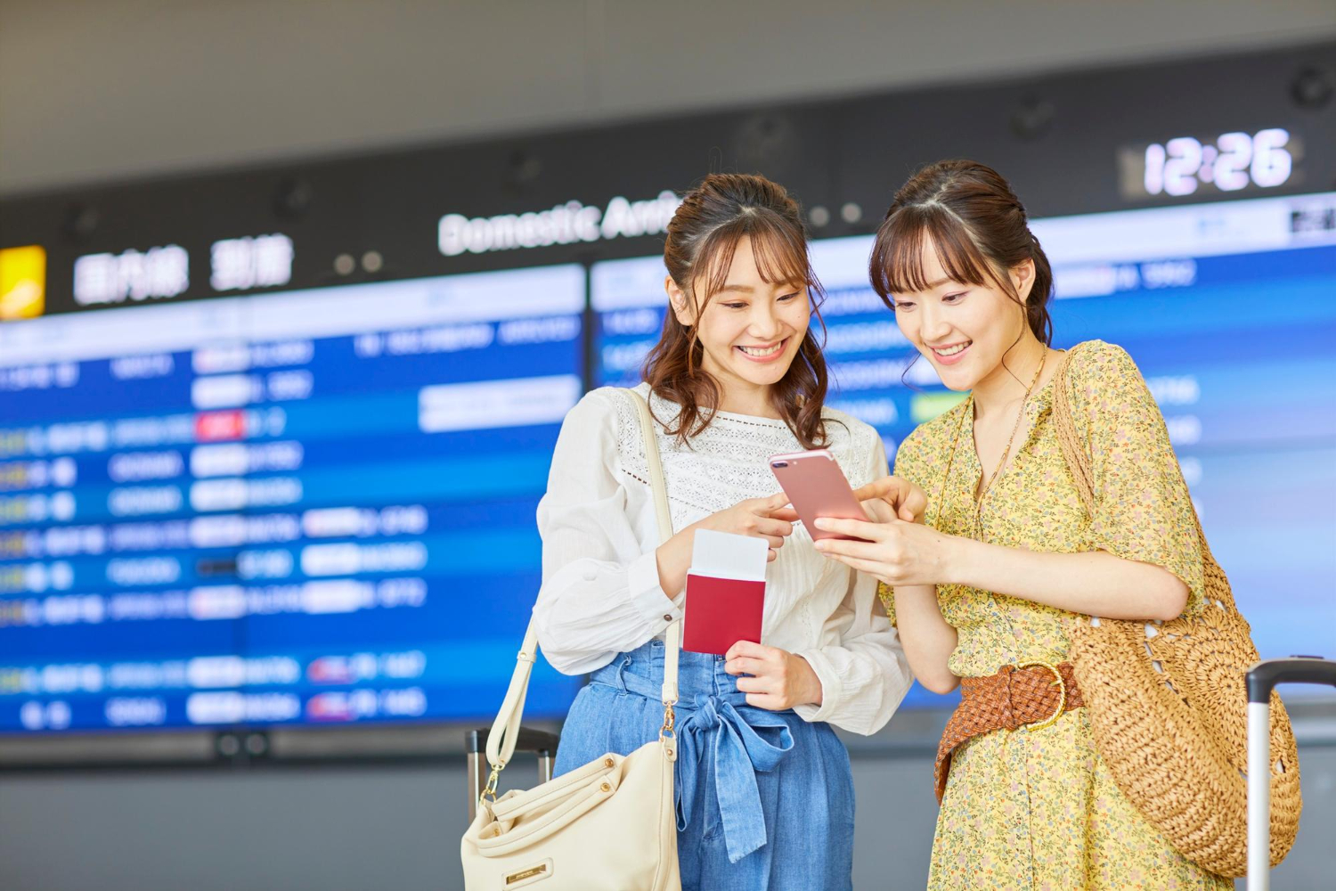 View of a friends checking their travel plans at an airport
